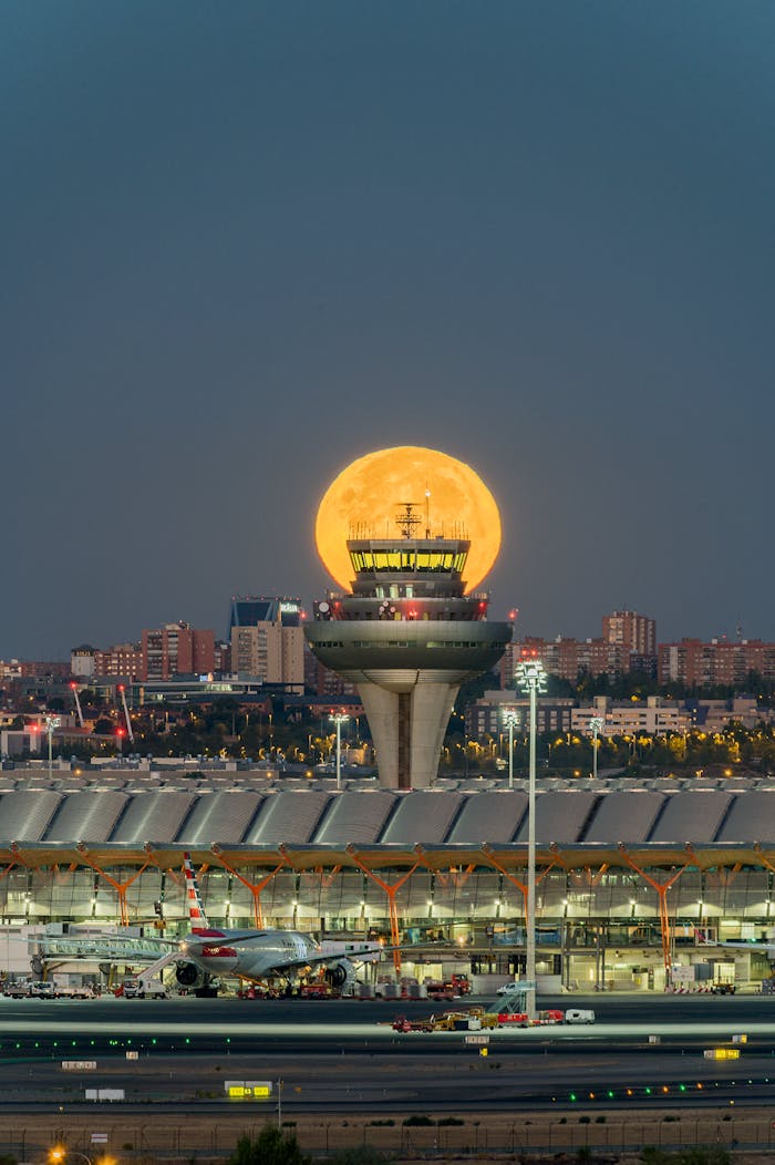 Stunning night shot of the full moon rising over the Madrid airport control tower, Spain.