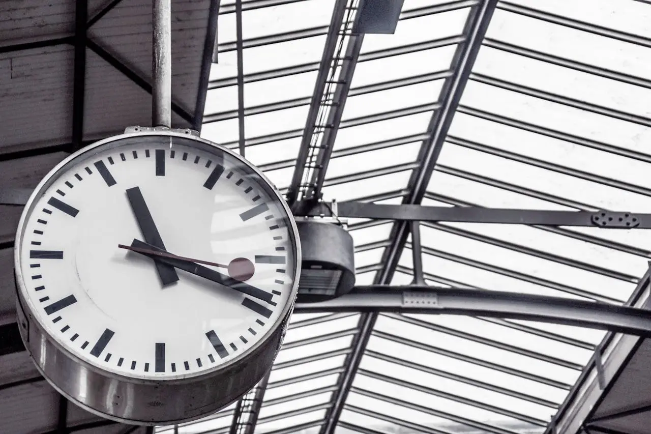 A detailed view of a large clock inside a modern railway station.
